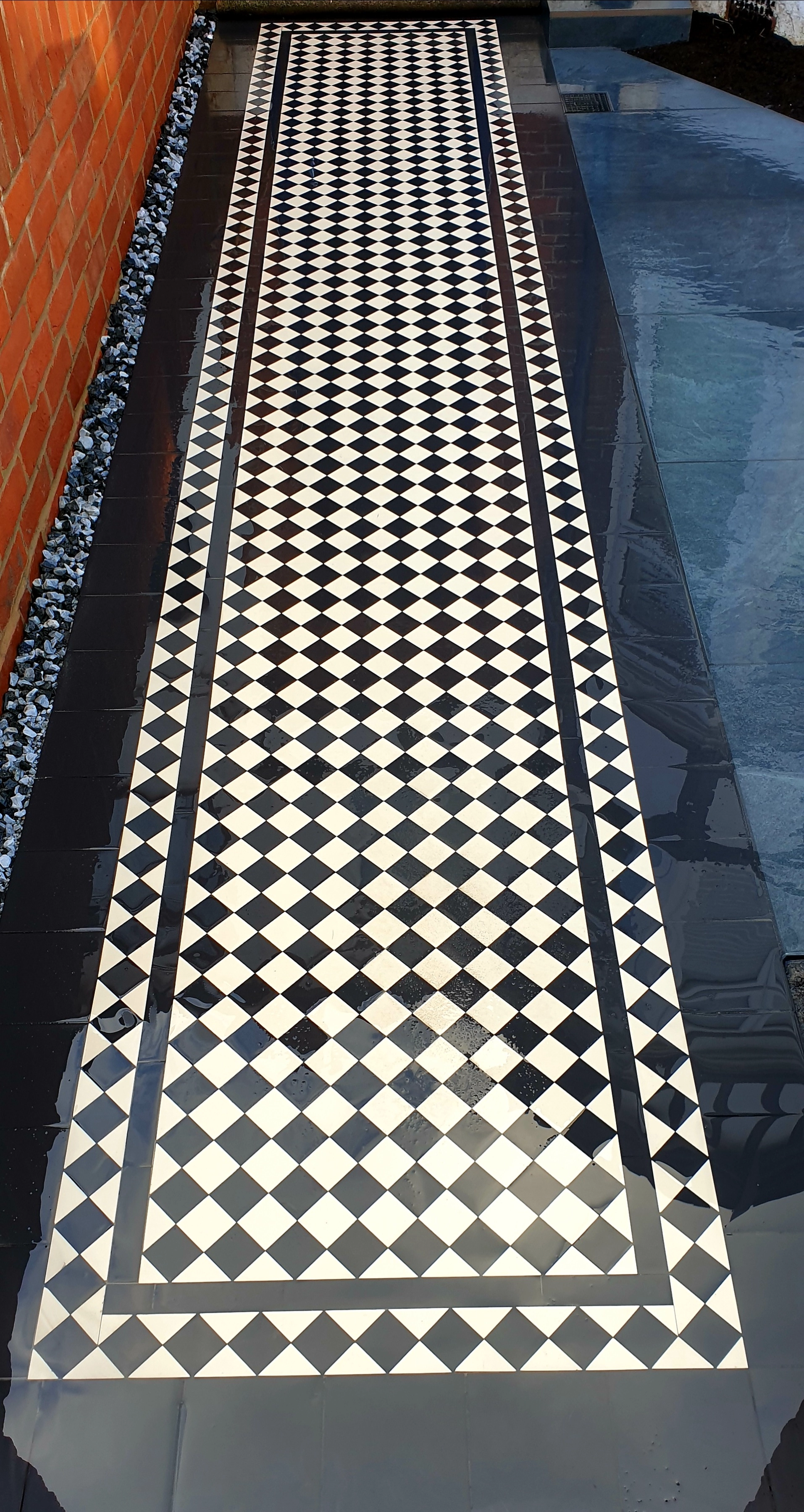 Black and white geometric tiled pathway leading to an entrance