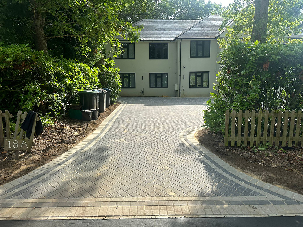After: Completed grey herringbone driveway with a charcoal border